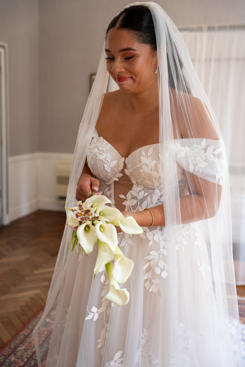 Mariée au voile avec son bouquet d'arums blancs